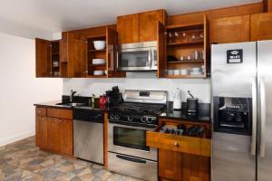 uma cozinha com utensílios de aço inoxidável e armários de madeira em Upscale 2BR Apartment with Patio em Washington