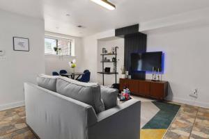 Upscale 2BR Apartment with Patio في واشنطن: غرفة معيشة مع أريكة وتلفزيون بشاشة مسطحة