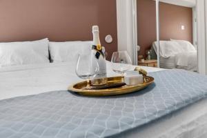 a tray with a bottle of wine and two glasses on a bed at Upscale 2BR Apartment with Patio in Washington