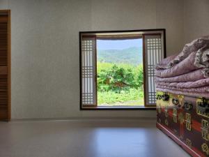 MiryangにあるHanok Soeun Houseの窓と景色を望むベッドが備わる客室です。