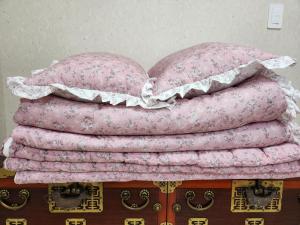 una pila de almohadas rosas sobre una mesa en Hanok Soeun House en Miryang