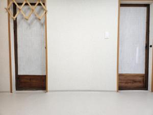 una habitación vacía con dos puertas y una pared en Hanok Soeun House en Miryang
