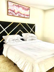 a bedroom with a large bed with white sheets and pillows at King & Queen in Downtown Columbus in Columbus