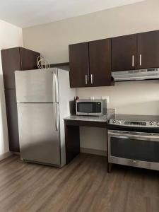 a kitchen with a stainless steel refrigerator and a microwave at King & Queen in Downtown Columbus in Columbus