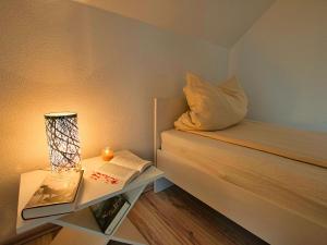 - une petite chambre avec un lit et une table avec un livre dans l'établissement Semi-detached house, Hasselfelde, à Hasselfelde