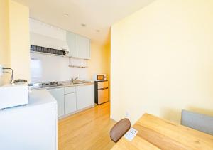 a kitchen with white cabinets and a wooden table at Ecot Shimozato 2 in Miyako-jima +57 photos