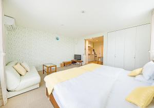宮古島にあるEcot 下里２の白いベッドルーム(大型ベッド1台、ソファ付)