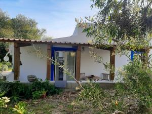 una pequeña casa blanca con una puerta azul en Studio with private pool enclosed garden and wifi at Santiago do Cacem 3 km away from the beach, en Santiago do Cacém