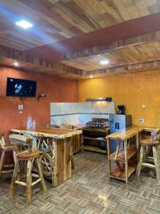 una cocina con mesas y sillas de madera en una habitación en Cabañas Rochivo Ranch en Creel