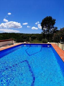 una gran piscina de agua azul en un patio en Studio with private pool enclosed garden and wifi at Santiago do Cacem 3 km away from the beach, en Santiago do Cacém
