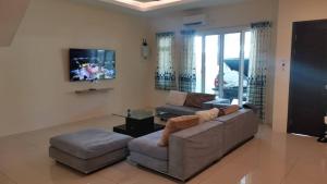 uma sala de estar com um sofá e uma mesa em Cozzy26 Homestay em Bintulu
