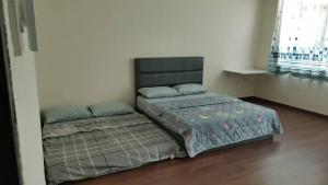 a bedroom with a large bed with a headboard at Cozzy26 Homestay in Bintulu