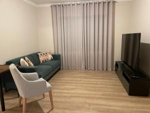 a living room with a couch and a television at Rise Traralgon in Traralgon