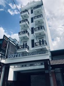 - un bâtiment blanc avec des balcons sur le côté dans l'établissement SaiGon Rose Hotel, à Hô-Chi-Minh-Ville