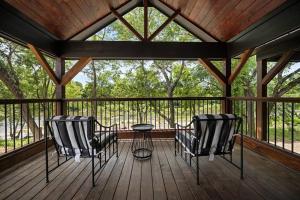 two chairs and a table on a screened in porch at Modern Riverfront, Starlink, Hot Tub, Broken Bow in Wright City