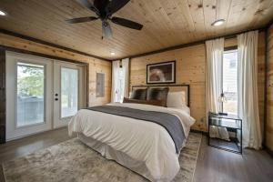 a bedroom with a bed and a ceiling fan at Modern Riverfront, Starlink, Hot Tub, Broken Bow in Wright City