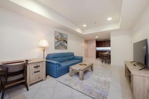 a living room with a blue couch and a tv at Luxury Princess Tower 1 Br Brand New Furnished apartment in Dubai