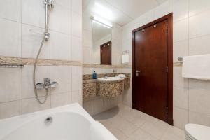 y baño con bañera, lavamanos y ducha. en Luxury Princess Tower 1 Br Brand New Furnished apartment en Dubái