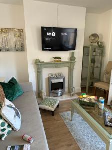 a living room with a fireplace with a tv above it at Ty Pentref - Cwmcarn Village House in Cwmcarn