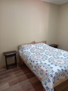 a bedroom with a bed with a blue and white comforter at El roble cabañas hualle in Pucón