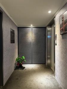 un pasillo con una puerta con una maceta. en Puremeworld Hotel en Taipéi