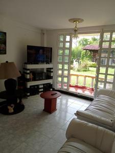 ein Wohnzimmer mit einem Sofa und einem TV in der Unterkunft Casa de campo los anturios in La Tebaida