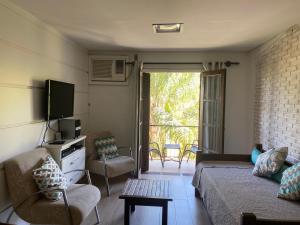 Una sala de estar con un sofá y un televisor. en Hotel Cavalinho Branco, en Águas de Lindóia