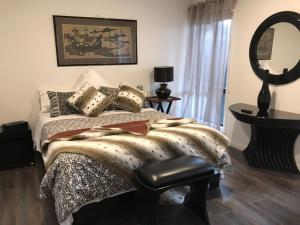 una camera da letto con un letto e un grande specchio di Angler's Rest a Sunderland Bay