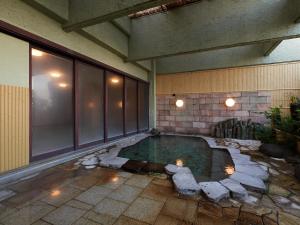 einem Wasserpool in der Mitte eines Gebäudes in der Unterkunft Tabist Izu Atagawa Onsen Hotel Gyokuryu in Higashiizu