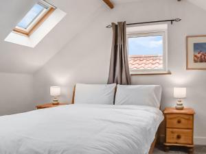 1 dormitorio con cama blanca y ventana en The Hay Barn-uk41602 en Stainton