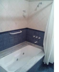 a bath tub in a bathroom with a shower at El lugar in Villa Gesell