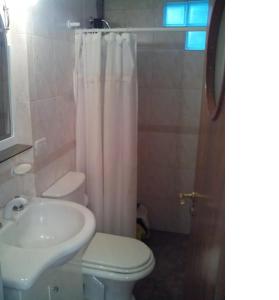 a bathroom with a white toilet and a sink at El lugar in Villa Gesell +6 photos
