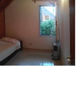 a bedroom with a bed and a window at El lugar in Villa Gesell