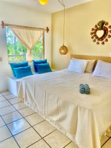 a bedroom with a large bed with two blue shoes on it at El Eden Escondido in Puerto Escondido +19 photos