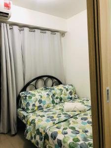een kleine slaapkamer met een bed met een gordijn bij Shore Residences @ Mall Of Asia Near International Airport Manila in Manilla