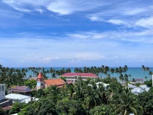 a view of a resort with palm trees and the ocean at Wanderlust Hotel in Mui Ne