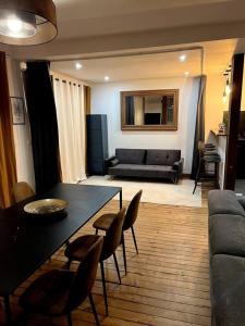 uma sala de estar com uma mesa e cadeiras e um sofá em Appartement en bord de Seine em Rouen