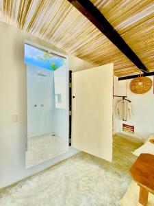 a room with a large glass door to a bedroom at El Eden Escondido in Puerto Escondido