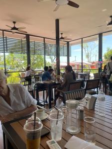 a group of people sitting at tables in a restaurant at HR Resort in Ban Dong Bang