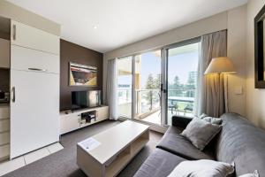 a living room with a couch and a large window at Belle Escapes - Seacrets at Glenelg in Glenelg