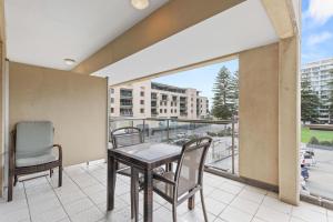 a balcony with a table and chairs and a view of a city at Belle Escapes - Glenelg Shores Studio in Glenelg