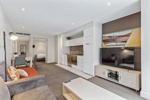 sala de estar con TV de pantalla plana grande en Belle Escapes - Glenelg Shores Family Stay, en Glenelg