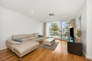 a living room with a couch and a table at Belle Escapes - Lazy Days on Colley Terrace in Glenelg