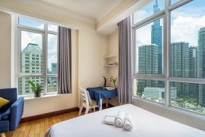 Habitación de hotel con cama y ventanas grandes. en The Manor 2 Luxury Apartment Free roof top pool en Ho Chi Minh