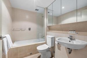 a bathroom with a toilet and a sink and a bath tub at Belle Escapes - Glenelg Seaside Family Stay in Glenelg +17 photos