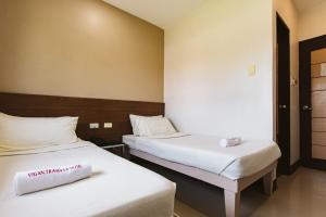 2 camas en una habitación con sábanas blancas en Vigan Traversa Hotel en Vigan
