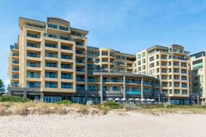 a large building on the beach next to the beach at Belle Escapes - Sunset Views at the Bay in Glenelg
