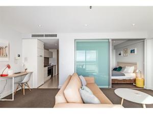 a living room with a couch and a bedroom at Belle Escapes - Absolute Ocean Views in Glenelg