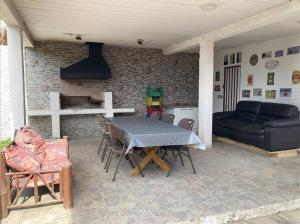 a patio with a table and chairs and a couch at Acogedora casa cerca del Bosque El Canelo in Algarrobo
