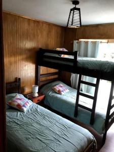 1 dormitorio con 2 literas y ventana en Acogedora casa cerca del Bosque El Canelo, en Algarrobo